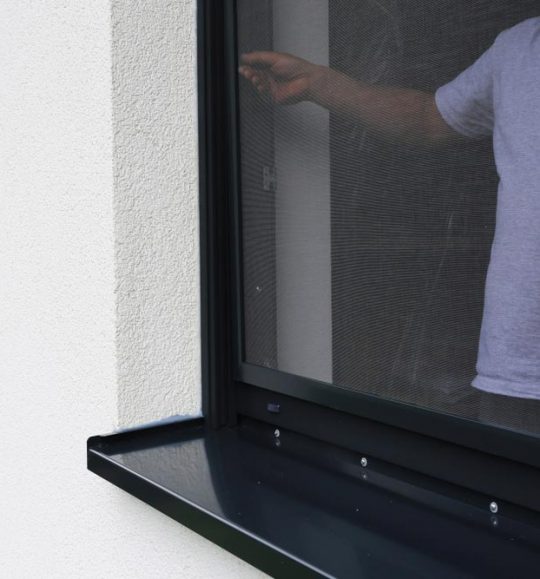 Man Installing Black Flyscreen Window — Door & Window Furnishings in the Northern Rivers