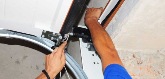 Man Repairing Garage Door — Door & Window Furnishings in the Northern Rivers
